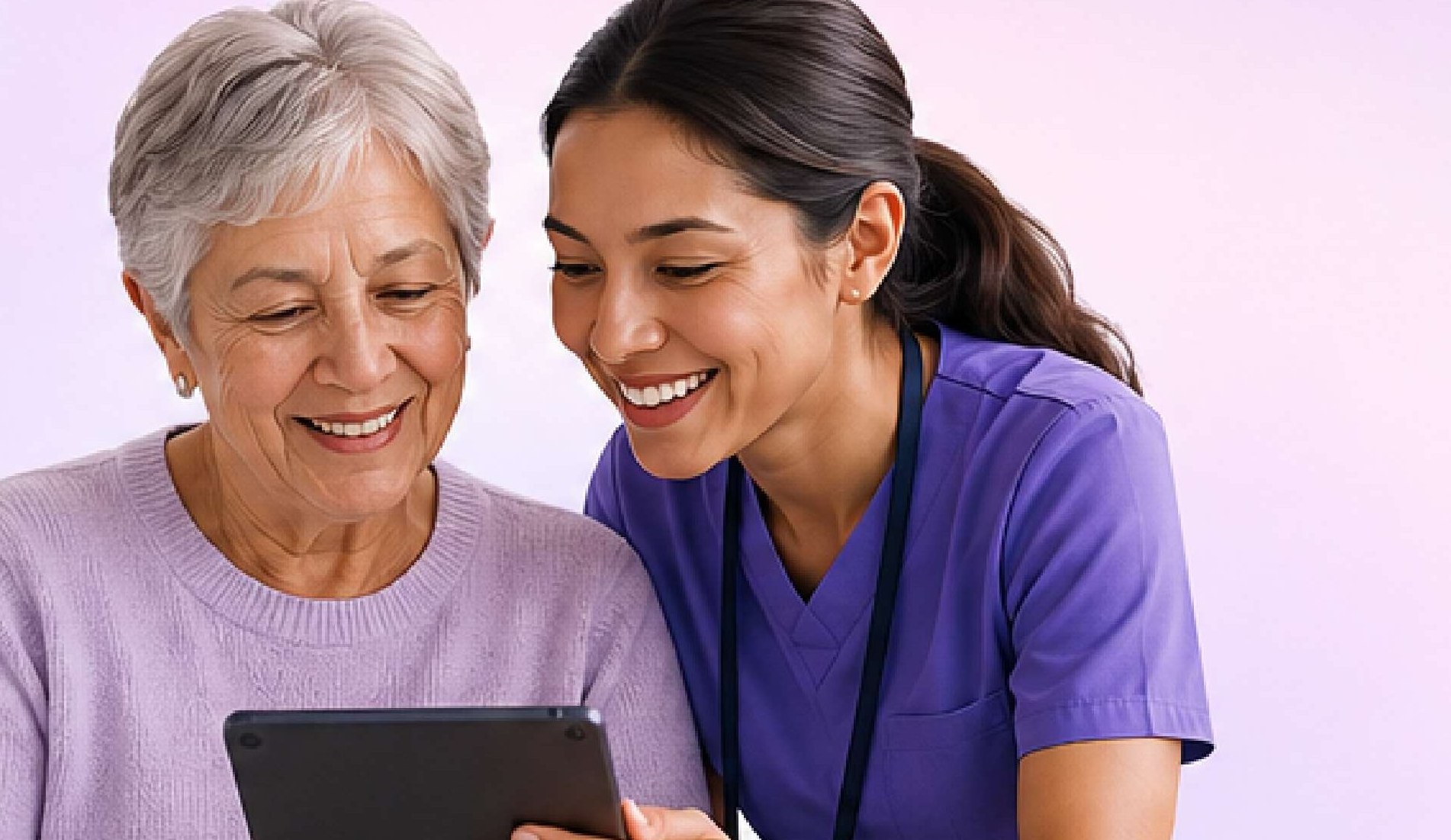 A care navigator in purple scrubs smiles with an older woman while they look at a tablet together